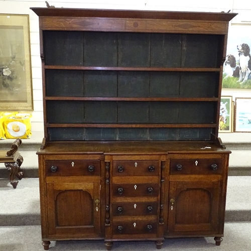 349K - A George III oak and mahogany break-front Anglesea Welsh dresser, with boarded open plate rack and d... 