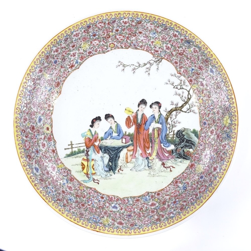 123 - A Chinese famille rose porcelain charger, with painted scene depicting 4 women in a garden in floral... 