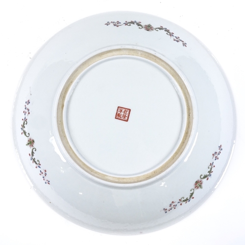 123 - A Chinese famille rose porcelain charger, with painted scene depicting 4 women in a garden in floral... 