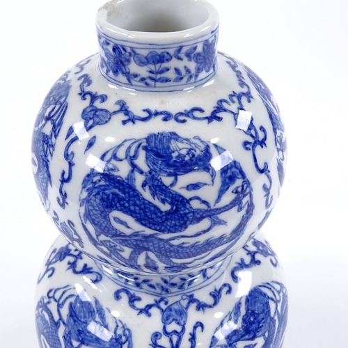 124 - A Chinese blue and white porcelain double gourd vase, with dragon decorated panels, height 21cm