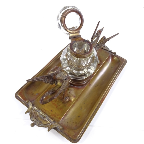 129 - A Victorian brass desk stand, with original cut-glass inkwell flanked by griffon figures