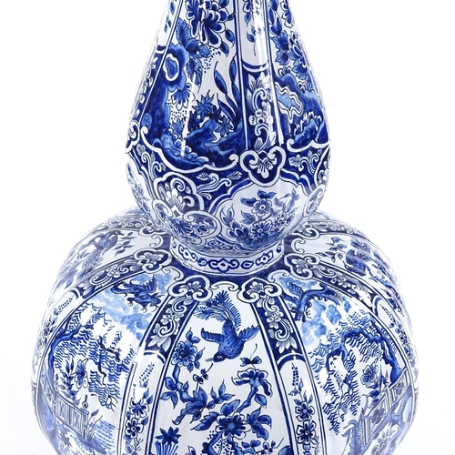 143 - A large Delft tin-glazed pottery double gourd vase, with hand painted exotic bird decorated panels, ... 