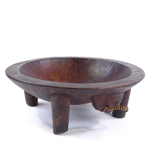 187 - A large Ethnic hardwood food bowl on 4 legs, carved from a single piece of wood, diameter 38cm