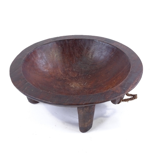 187 - A large Ethnic hardwood food bowl on 4 legs, carved from a single piece of wood, diameter 38cm