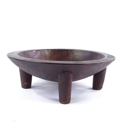 187 - A large Ethnic hardwood food bowl on 4 legs, carved from a single piece of wood, diameter 38cm