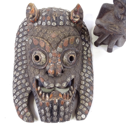 195 - A Nepalese carved and stained wood mask with metal studded decoration, height 36cm, and a carved woo... 