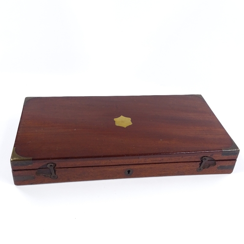 16 - A brass-bound mahogany gun box, with fitted interior for a pair of pistols, label for Robert Hughes ... 