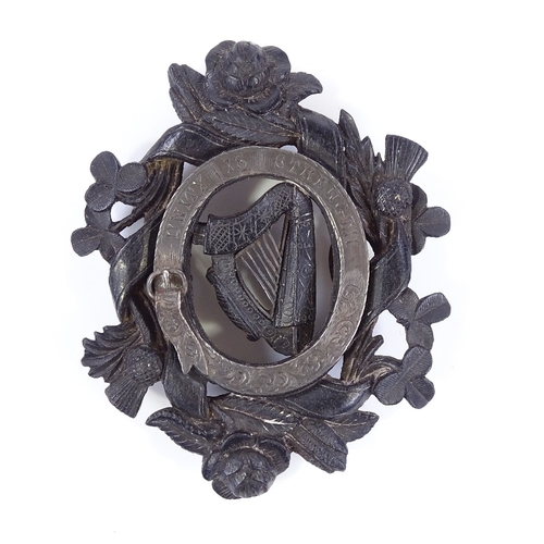 62 - A Victorian carved bog oak Unity badge, with silver mount and shamrock rose and thistle designs, len... 