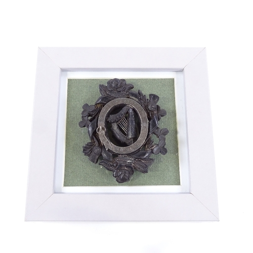 62 - A Victorian carved bog oak Unity badge, with silver mount and shamrock rose and thistle designs, len... 