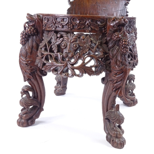 84 - A 19th century Burmese hardwood chair, allover carved and pierced decoration with lion masks and lio... 