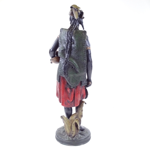 99 - A patinated and painted spelter figure of a West Indian woman carrying a pineapple, height 51cm