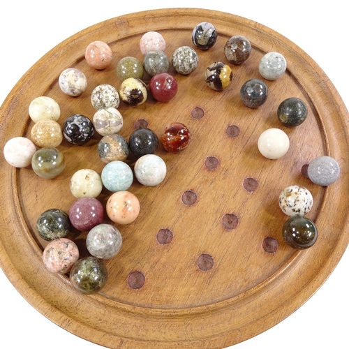 235 - A solitaire board, diameter 32cm, together with a set of marble and hardstone balls, diameter 25mm