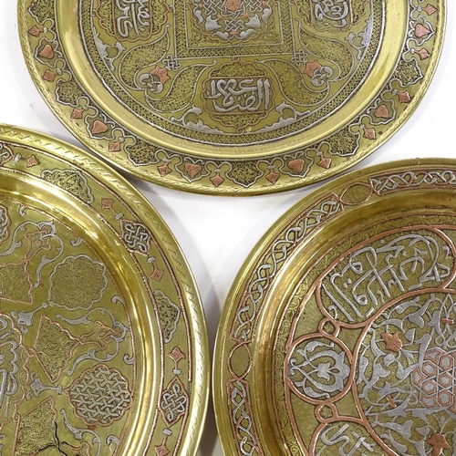 242 - 3 Islamic brass plates with silver and copper inlaid decoration and text, largest 31cm across (3)