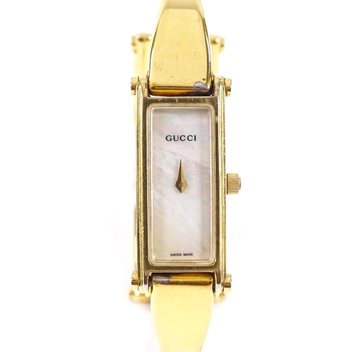 415 - GUCCI - a lady's gold plated stainless steel 1500L quartz bangle wristwatch, rectangular mother-of-p... 