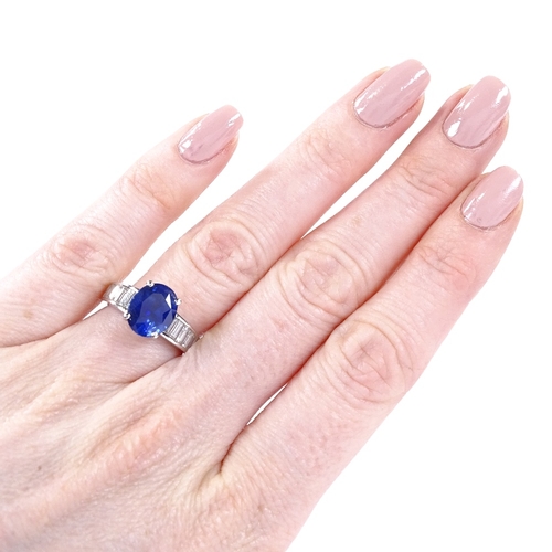 451 - An unmarked white gold sapphire and baguette-cut diamond ring, oval-cut sapphire approx 4ct, total d... 