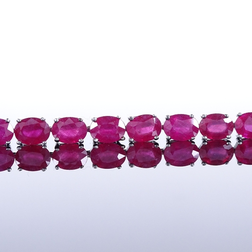 455 - A sterling silver ruby line bracelet, total oval-cut ruby content approx 35ct, bracelet length 18.5c... 