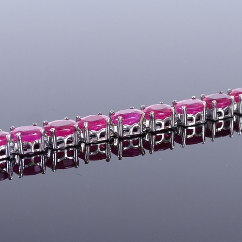 455 - A sterling silver ruby line bracelet, total oval-cut ruby content approx 35ct, bracelet length 18.5c... 