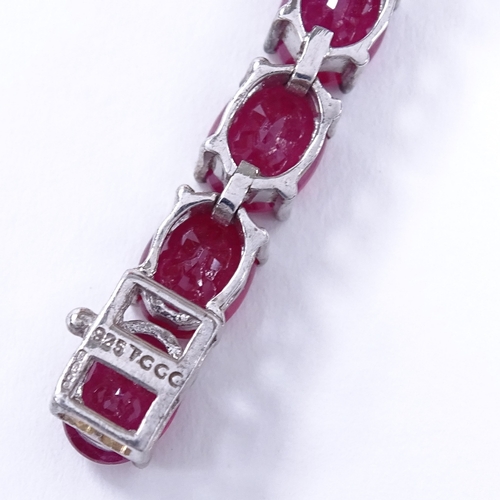 455 - A sterling silver ruby line bracelet, total oval-cut ruby content approx 35ct, bracelet length 18.5c... 