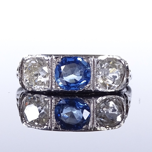 470 - An unmarked platinum 3-stone sapphire and diamond half-hoop panel ring, pierced shoulders and bridge... 