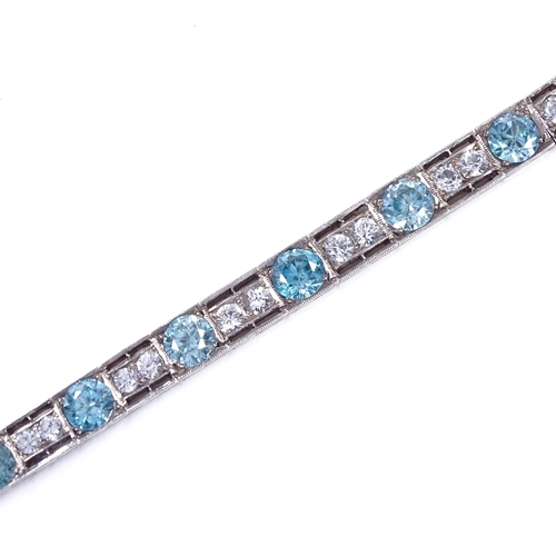 480 - An Art Deco unmarked silver blue topaz and white sapphire line panel bracelet, openwork settings wit... 