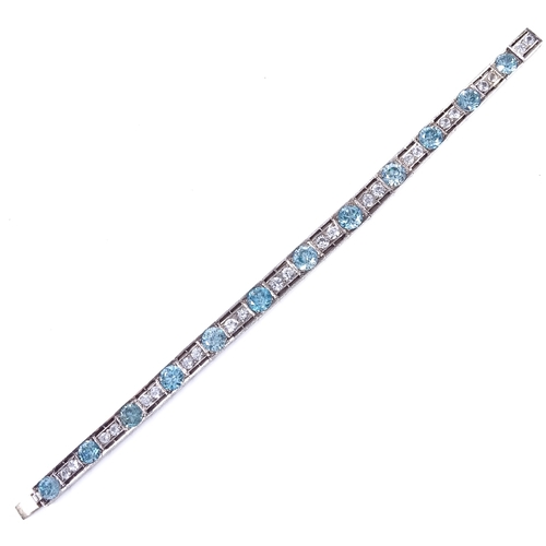 480 - An Art Deco unmarked silver blue topaz and white sapphire line panel bracelet, openwork settings wit... 