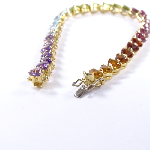 482 - An 18ct gold heart-cut multi-gem line bracelet, including amethyst, topaz, peridot and citrines, bra... 