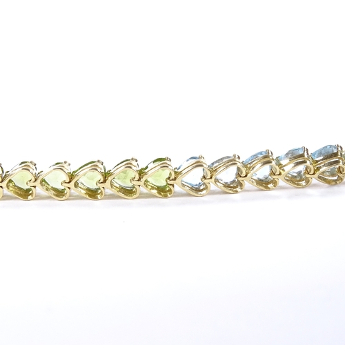 482 - An 18ct gold heart-cut multi-gem line bracelet, including amethyst, topaz, peridot and citrines, bra... 