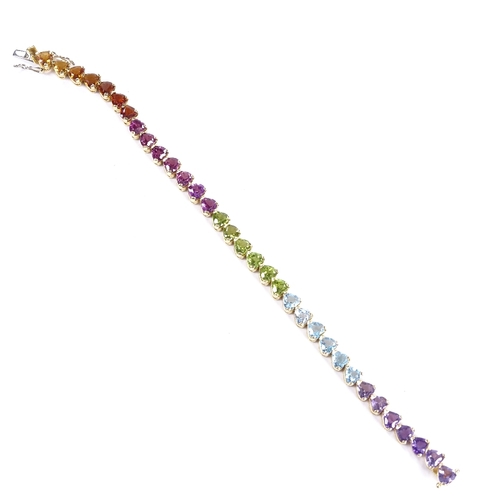 482 - An 18ct gold heart-cut multi-gem line bracelet, including amethyst, topaz, peridot and citrines, bra... 