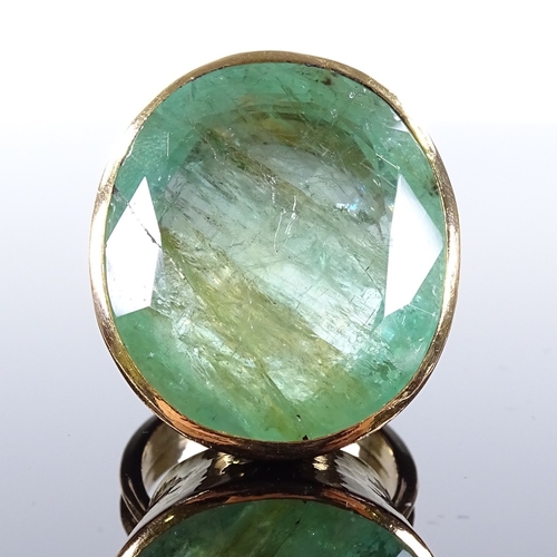 484 - A large handmade 18ct gold solitaire emerald dress ring, oval-cut emerald approx 50ct, in planished ... 