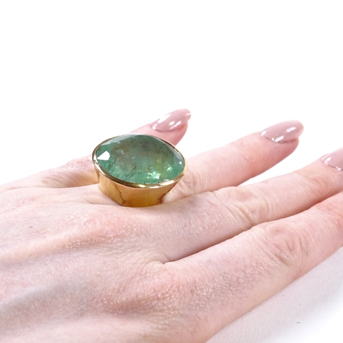 484 - A large handmade 18ct gold solitaire emerald dress ring, oval-cut emerald approx 50ct, in planished ... 