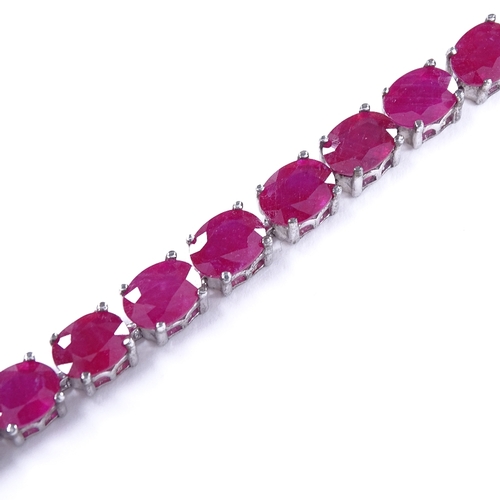 455 - A sterling silver ruby line bracelet, total oval-cut ruby content approx 35ct, bracelet length 18.5c... 