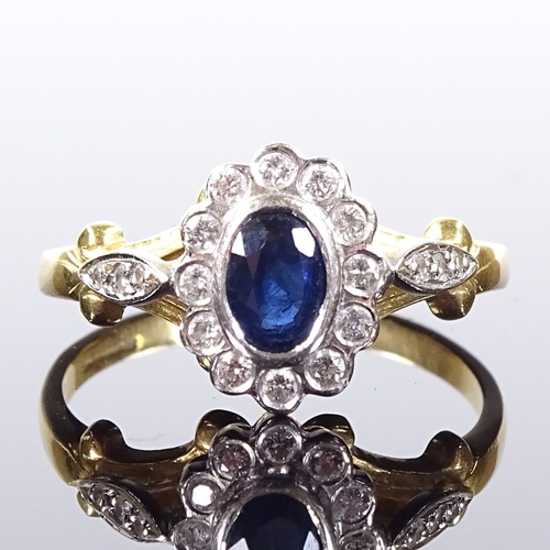 514 - An 18ct gold sapphire and diamond cluster ring, with diamond set foliate shoulders, setting height 1... 