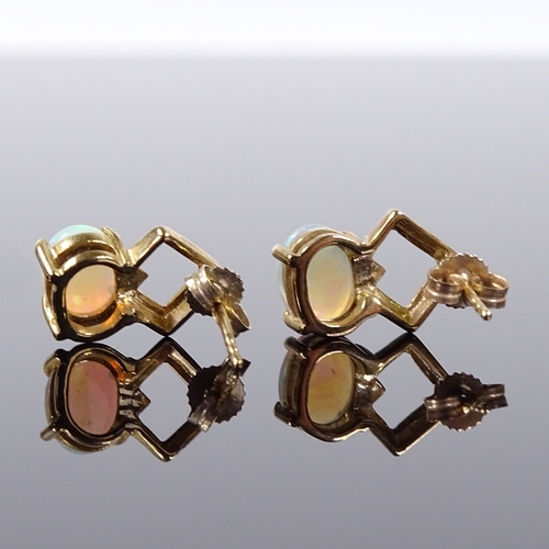 516 - A pair of 9ct gold opal earrings, stud fittings with openwork settings, height excluding fitting 13.... 