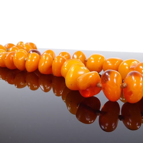 579 - A simulated butterscotch amber single strand necklace, largest bead length 18.6mm, necklace length 5... 