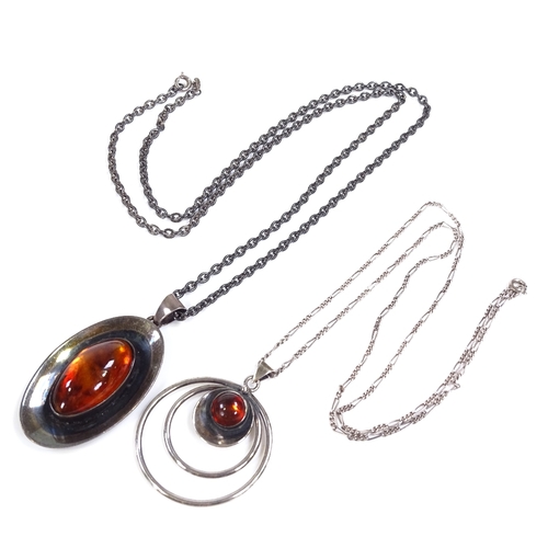 584 - 2 N.E. From Danish sterling silver and amber pendant necklaces, stylised form, circular pendant diam... 