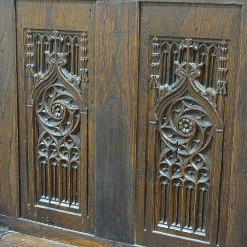 305 - An Antique carved and panelled Gothic style hall settle, with relief carved tracery panelled back, w... 