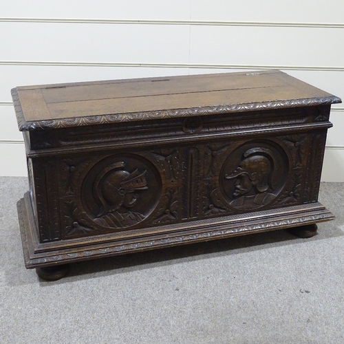 311 - An 18th century Continental oak coffer, the relief carved front decorated with knights in armour, wi... 