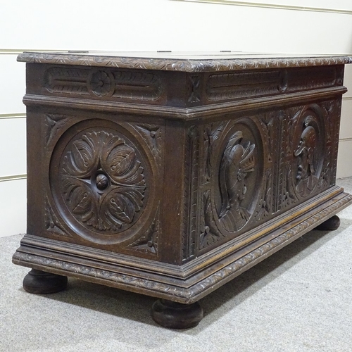 311 - An 18th century Continental oak coffer, the relief carved front decorated with knights in armour, wi... 