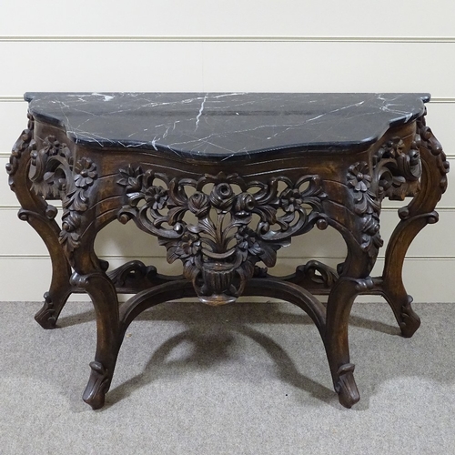 313 - An ornate Rococo style carved walnut console table with shaped marble top, carved and pierced floral... 