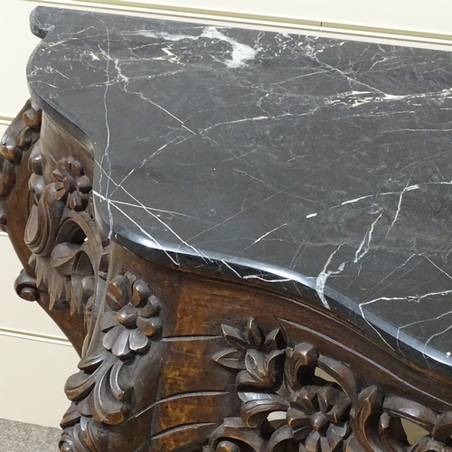 313 - An ornate Rococo style carved walnut console table with shaped marble top, carved and pierced floral... 