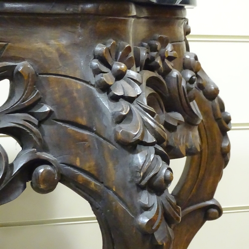 313 - An ornate Rococo style carved walnut console table with shaped marble top, carved and pierced floral... 