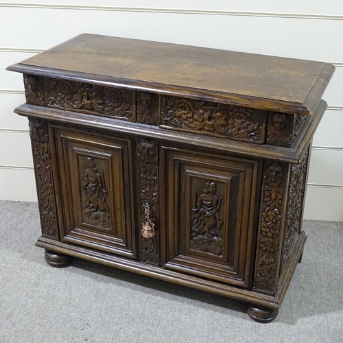 314 - An 18th/19th century French oak side cupboard, with relief carved frieze drawers and fielded cupboar... 