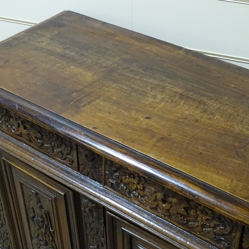 314 - An 18th/19th century French oak side cupboard, with relief carved frieze drawers and fielded cupboar... 