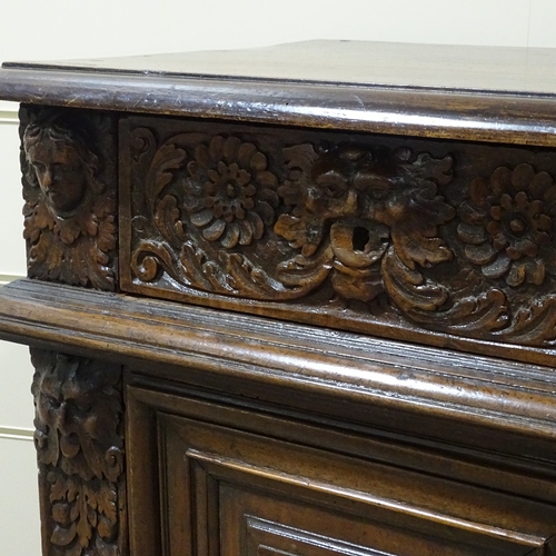 314 - An 18th/19th century French oak side cupboard, with relief carved frieze drawers and fielded cupboar... 