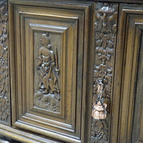 314 - An 18th/19th century French oak side cupboard, with relief carved frieze drawers and fielded cupboar... 