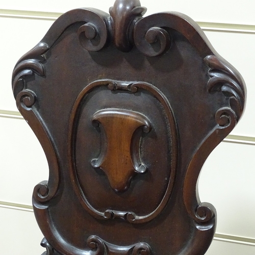 315 - A pair of Victorian mahogany hall chairs with shield-shaped backs