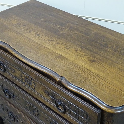 318 - A 19th century French oak 3-drawer commode with relief carved drawer fronts, width 3'7