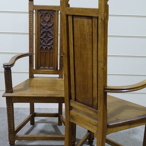 320 - A pair of Gothic style oak hall chairs, with relief carved tracery panelled backs