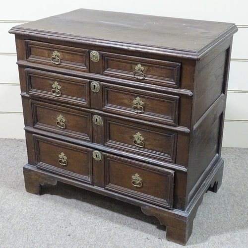 321 - An 18th century joined oak chest of 4 long drawers, with panelled drawer fronts and bracket feet, wi... 