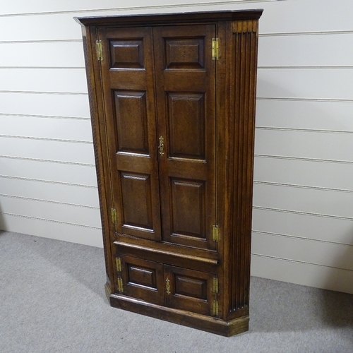 326 - An 18th century floor standing panelled oak corner cupboard, with fluted corners